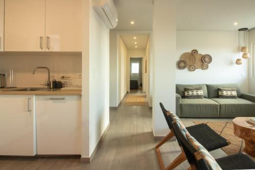a kitchen and a living room with a couch at Bay House in Ponta Delgada
