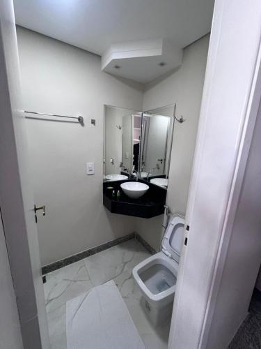 a bathroom with a toilet and a sink and a mirror at Ancona Center Hotel in Amparo