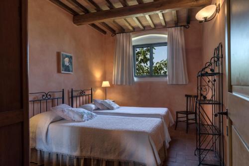 a bedroom with two beds and a window at Il Borghetto Tuscan Holidays in San Gimignano