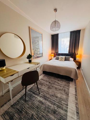 a bedroom with a bed and a desk and a mirror at ApartamentySnu, Apartament Nad Potokiem in Radom