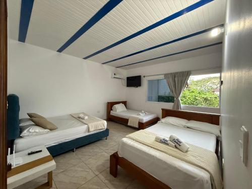 a bedroom with two beds and a blue ceiling at Hotel Santorini Doradal in Doradal