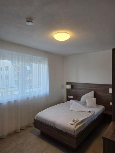 a bedroom with a bed and a large window at Hotel & Mühlenapartments by AVERA Gernsbach GmbH in Gernsbach