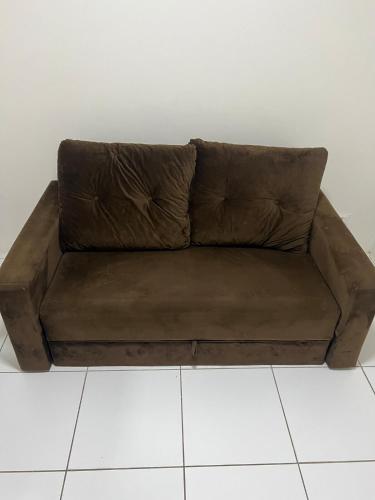 a brown couch sitting on top of a white floor at Flat on Mount Castelo Sairé in Sairé