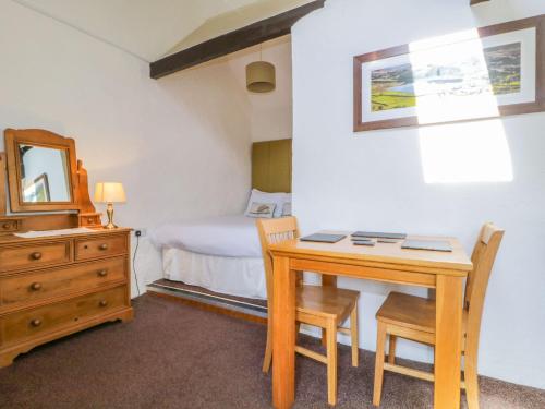 a bedroom with a desk and a bed with a mirror at Mews Cottage 6 in Keswick