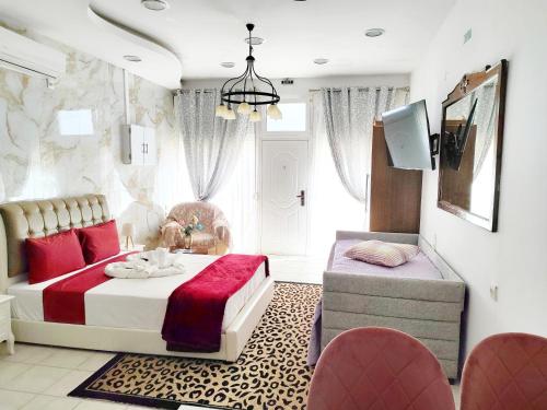a bedroom with a bed and a chair and a tv at Sweet Home Suite in Korinthos