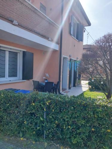 a house with a table and chairs in a yard at A 2 passi dal mare in Scardovari