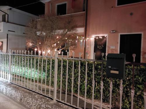 a fence in front of a building with christmas lights at A 2 passi dal mare in Scardovari