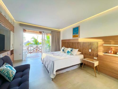 a bedroom with a bed and a tv and a couch at Laguna Beach Ecohotel in Tolú