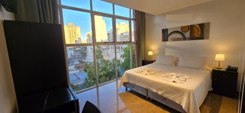 a bedroom with a bed and a large window at Hotel del Sol in La Plata