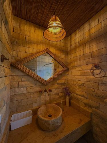 a bathroom with a stone sink and a mirror at Laguna Beach Ecohotel in Tolú
