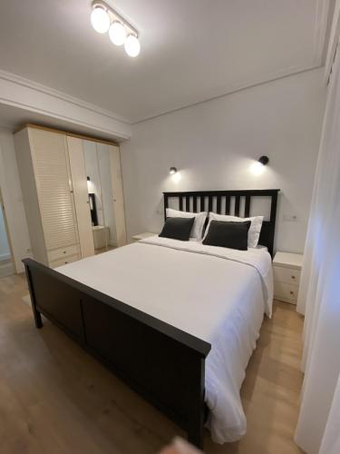 a bedroom with a large bed with white sheets and pillows at Apartamento en Eibar in Éibar