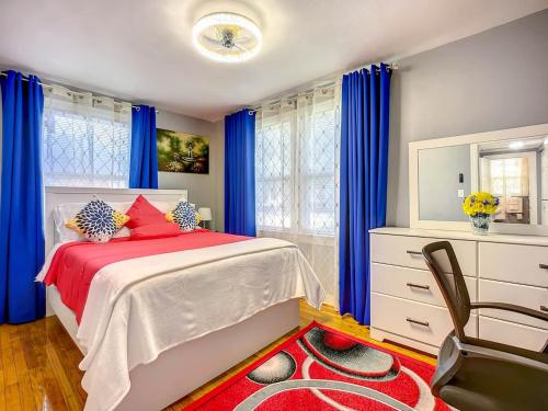 a bedroom with a bed with blue curtains and a chair at Private 2BR 10 Min to Airport & Downtown in Jacksonville