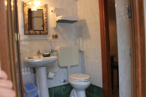 a bathroom with a toilet and a sink and a mirror at Alice Affittacamere in Cesana Torinese