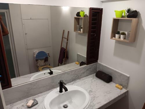un bagno con lavandino e specchio di BAMBOU a La Trinité