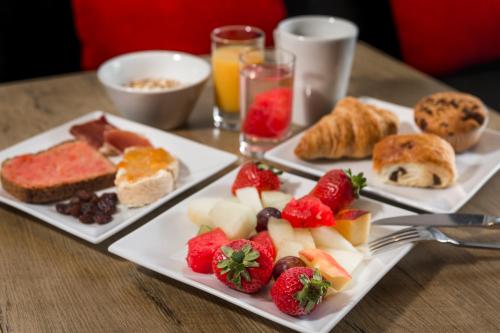 a table with three plates of food with fruit and pastries at Hotel ibis Faro Algarve in Faro