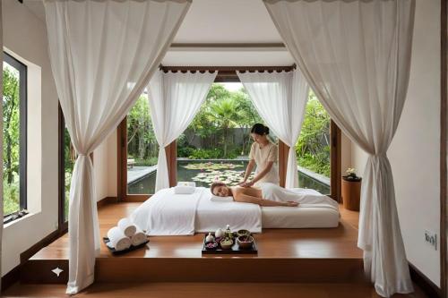 a woman sitting on a bed in a bedroom at Wisdom Park Caravan Camp Pattaya in Ban Khao Mai Kaeo