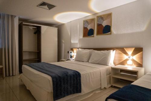 a hotel room with a large bed and a room with two beds at Tambaú Beira-Mar in João Pessoa