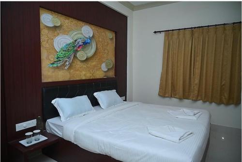 a bedroom with a bed with a painting on the wall at MAHAMAYA CONVENTION and HOTEL in Mālatīpātpur