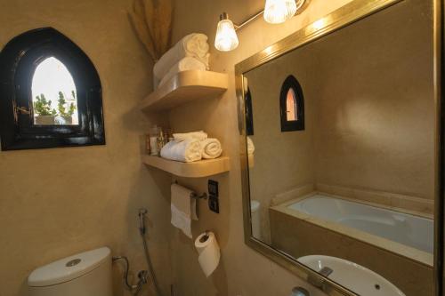 a bathroom with a toilet and a sink and a mirror at Riad Malak Palmeraie in Marrakesh