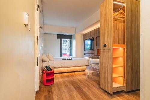 ein kleines Schlafzimmer mit Bett und Schreibtisch in der Unterkunft Hotel Nodo - El primer hotel de negocios en Chile in Santiago