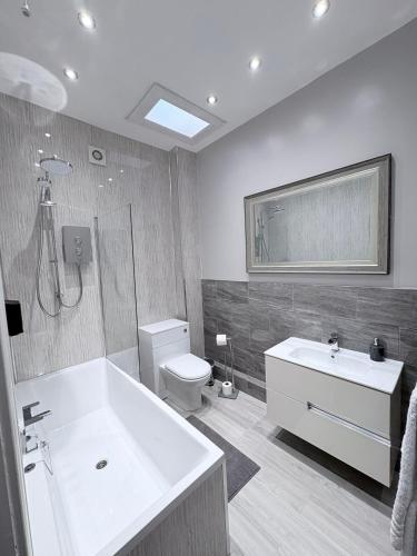 a bathroom with a tub and a toilet and a sink at Crown & Crossed Swords in Shotley Bridge