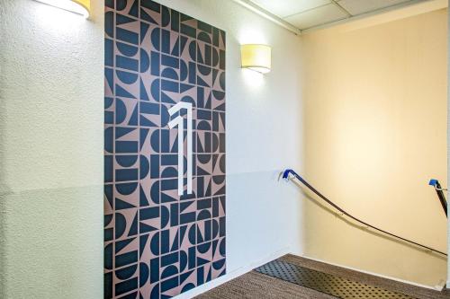 a bathroom with a patterned wall in a room at Ibis Budget Toulon Centre in Toulon