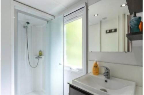 a bathroom with a sink and a shower and a mirror at Sun Sea camping le Bosc in Saint-Cyprien