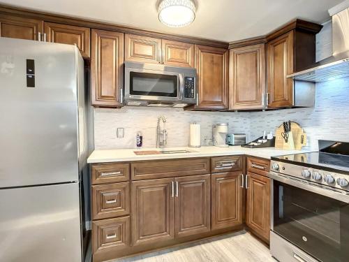 a kitchen with wooden cabinets and a stainless steel refrigerator at Private Guest House 10 Min to Airport & Downtown in Jacksonville