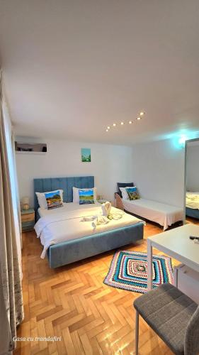 a bedroom with two beds and a wooden floor at Casa cu Trandafiri Murighiol in Murighiol