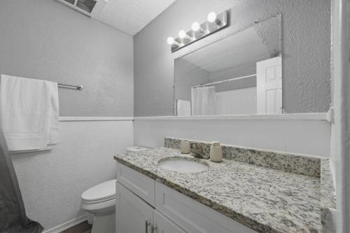 a bathroom with a sink and a toilet and a mirror at Modern 2BR townhome with full kitchen & dining in Arlington