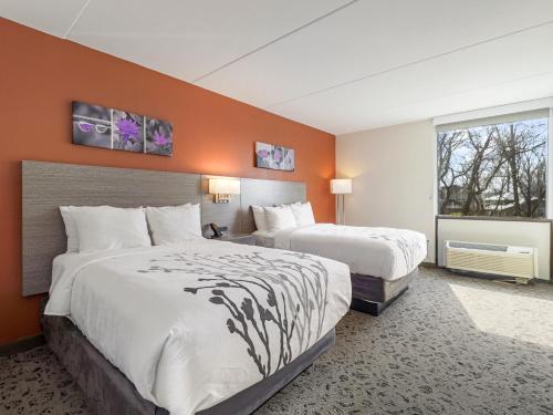 a hotel room with two beds and a window at Sleep Inn Chambersburg in Chambersburg