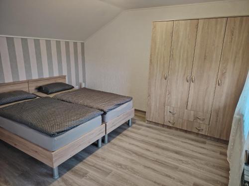 a bedroom with two beds and wooden cabinets at Apartman ŠIPA in Bjelovar