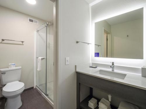 a bathroom with a toilet and a sink and a mirror at Sleep Inn Chambersburg in Chambersburg