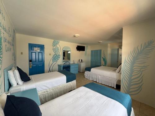 a hotel room with two beds and a mirror at Seaview Beach Hotel in Philipsburg