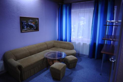 a living room with a couch and a table at Perlyna Krasiyi in Vyshka