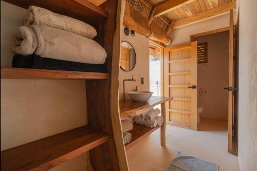 a room with a bathroom with a sink and towels at Mangle Rojo Palafitos in La Manzanilla