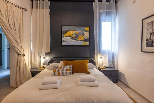 a bedroom with a large bed with two pillows at Elegant Maltese Townhouse in Attard
