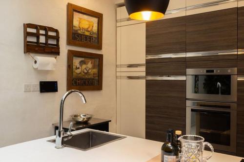 a kitchen with a sink and a stainless steel oven at Elegant Maltese Townhouse in Attard