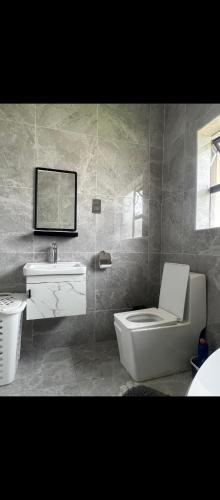 a bathroom with a toilet and a sink at Cozy Corner Monavale in Harare
