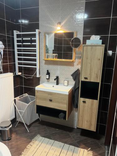 a bathroom with a sink and a mirror at GRAND HOME Apartman in Sárospatak