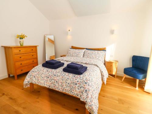a bedroom with a bed with two blue towels on it at The Pebble in Dorchester