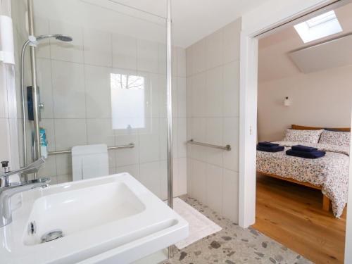 a bathroom with a sink and a bed at The Pebble in Dorchester