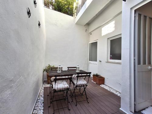 a patio with a table and chairs on a porch at Travessa Houses in Lisbon