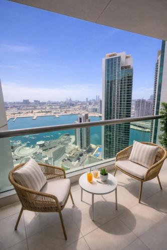 a balcony with chairs and a table and a view of the city at Reem Island, Unique furnished one bedroom with amazing seaview in Abu Dhabi