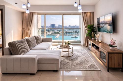 a living room with a couch and a large window at Reem Island, Unique furnished one bedroom with amazing seaview in Abu Dhabi