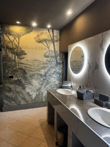 a bathroom with two sinks and a mural on the wall at Villa Altieri in Albano Laziale