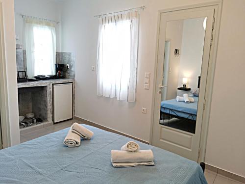 a bedroom with a blue bed with towels on it at Meltemi Chora Amorgos Panoramic View in Amorgos