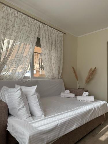 a bed with white sheets and pillows in a bedroom at Alexandra Apartment in Agíasma