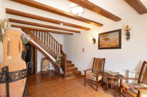 a living room with a staircase and a chair at Cal Vidal in Mura