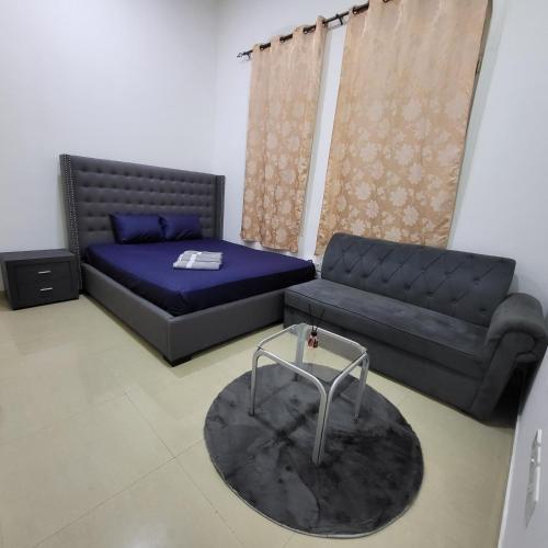 a living room with a bed and a couch at Cliftin Studio Apartment in Abu Dhabi